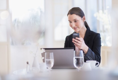 Businesswoman working on laptop in restaurant.