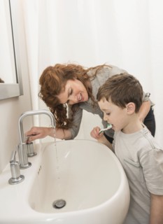 son (6-7) and mother brushing teeth.