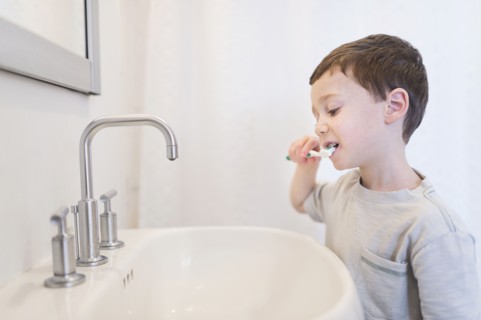 boy (6-7) brushing teeth.