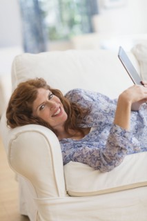 Woman lying on sofa and using laptop.