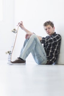 Teenage boy (16-17) holding skateboard.