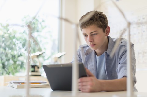 Teenage boy (16-17) using digital tablet in laboratory.