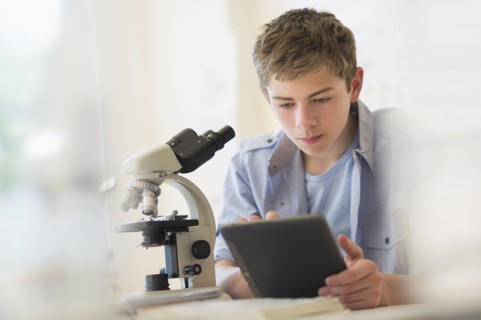 Teenage boy (16-17) using digital tablet in laboratory.