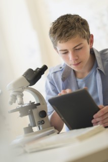 Teenage boy (16-17) using digital tablet in laboratory.
