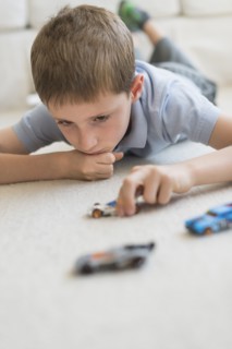 boy (8-9) playing with toy cars.