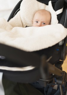 Portrait of baby boy (2-5 months) sitting in stroller.