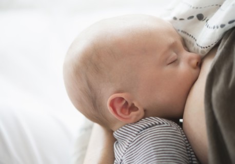 Close up of baby boy (2-5 months) suckling mother's breast.