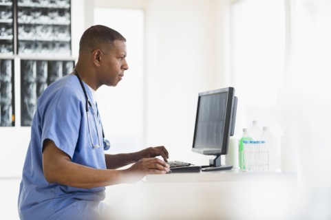 Male doctor in hospital using digital tablet.
