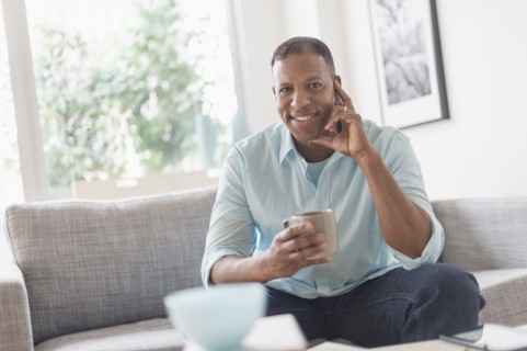 Portrait of man sitting on sofa at home.