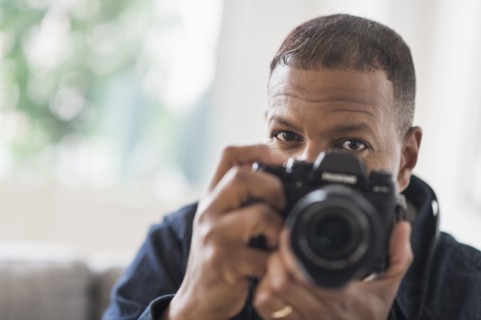 Portrait of man holding digital camera.