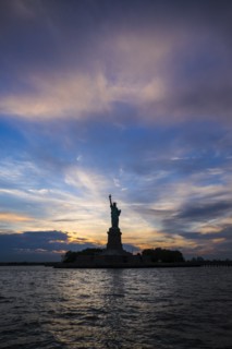 Silhouette of Statue of Liberty at sunset.