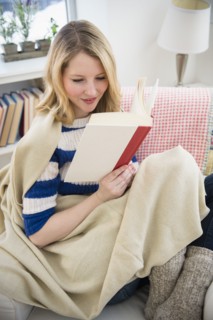 Blond woman reading on sofa.
Photo : Jamie Grill
