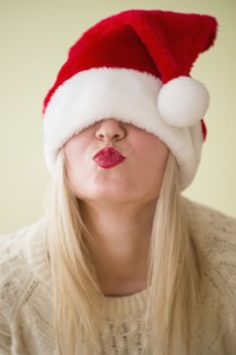Studio Shot of woman wearing santa hat and puckering.
Photo : Jamie Grill