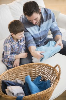Father sorting laundry with his son (8-9) .
Photo : Jamie Grill
