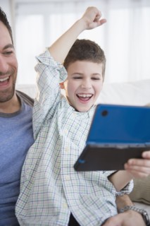 Father and son (8-9) playing video game .
Photo : Jamie Grill