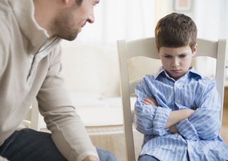 Father looking at displeased son (8-9) .
Photo : Jamie Grill
