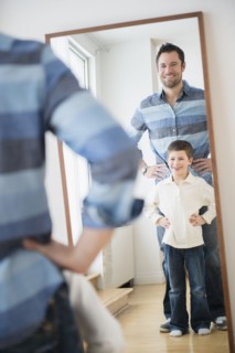 Father and son (8-9) looking at their reflection in mirror.
Photo : Jamie Grill