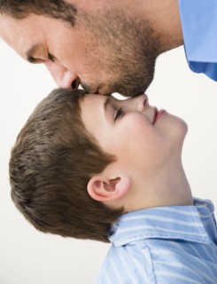 Father kissing son (8-9) .
Photo : Jamie Grill