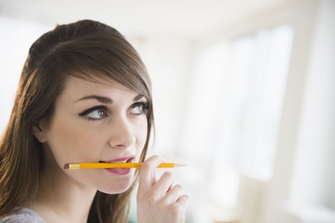 Young woman holding pencil in her mouth.
Photo : Jamie Grill