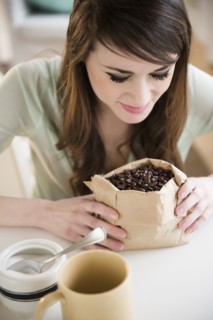 Young woman smelling coffee beans.
Photo : Jamie Grill