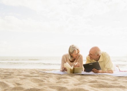 Senior couple reading books on beach.
Photo : Daniel Grill