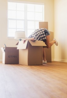 Young woman looking into box in her new house.
Photo : Daniel Grill