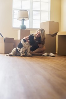 Young woman with dog in their new house.
Photo : Daniel Grill