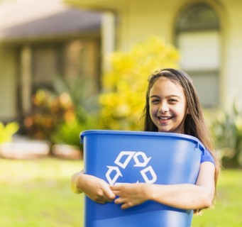 Portrait of girl ( 8-9) holding recycling bin.
Photo : Daniel Grill