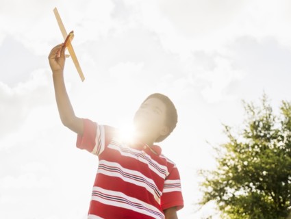 boy (6-7) playing with toy airplane.
Photo : Daniel Grill
