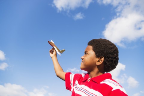boy (6-7) playing with toy airplane.
Photo : Daniel Grill