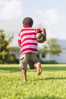 boy (6-7) playing football.
Photo : Daniel Grill