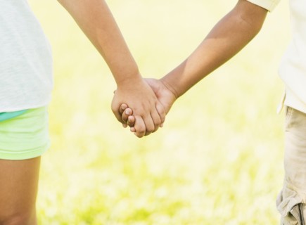 girl ( 8-9) and boy (6-7) holding hands, close up.
Photo : Daniel Grill