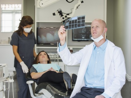 Dentist looking at x-ray.
