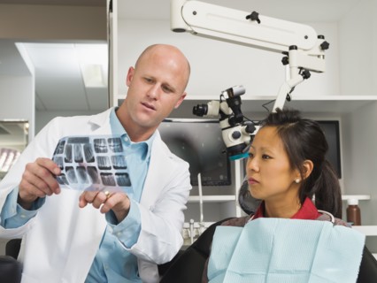 Dentist holding patient's x-ray.