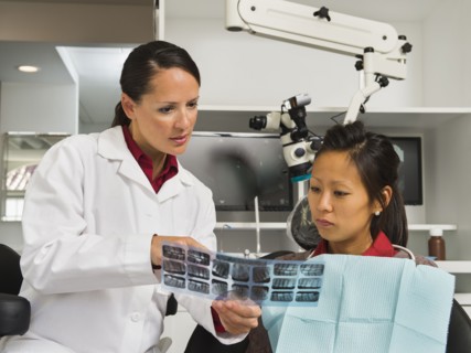 Dentist holding patient's x-ray.