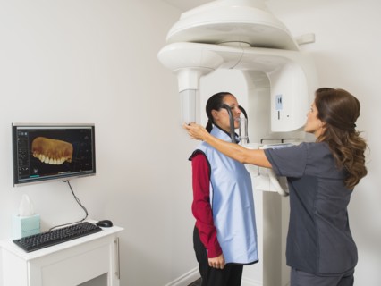 Assistant making x-ray image of patient teeth.