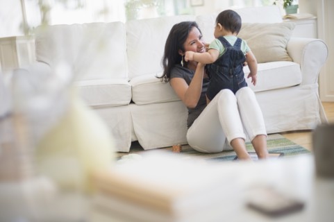 Mother playing with her son (6-11 months) in living room.