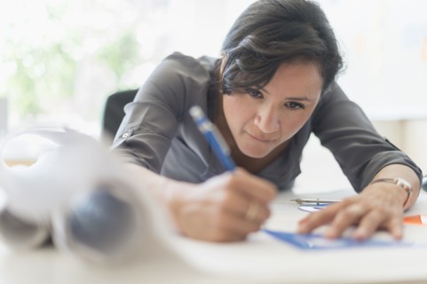 Woman drawing blueprints.
