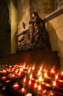 Candles in front of Virgin Mary statue in Monastery of Jeronimos. Lisbon, Portugal.
