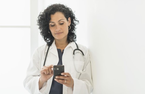 Female doctor using cell phone.