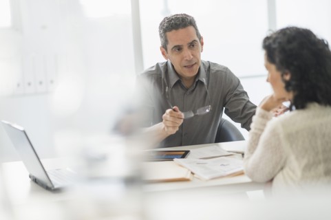 Business people talking at desk in office.