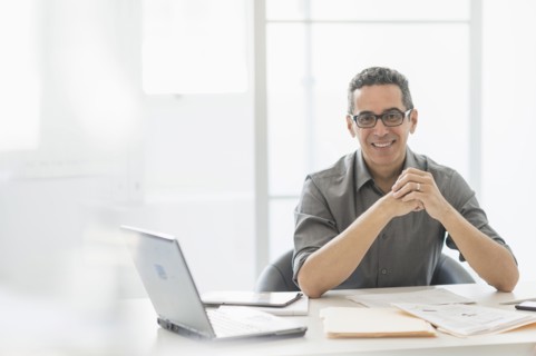 Portrait of man at desk in office.