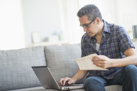 Man doing home finances with laptop.