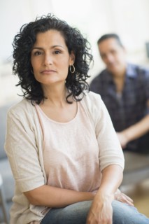 Portrait of woman with man in background.