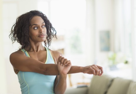 Woman stretching in living room.