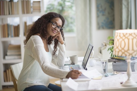 Woman using laptop in home office.