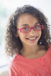 Portrait of schoolgirl (8-9) wearing pink eyeglasses.