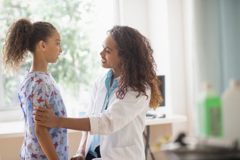 Female doctor examining girl (8-9).