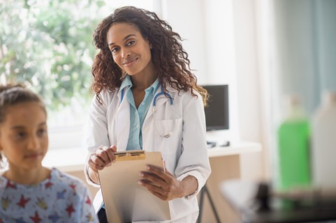 Female doctor examining girl (8-9).