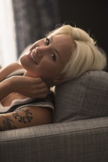 Portrait of blonde woman relaxing on sofa.